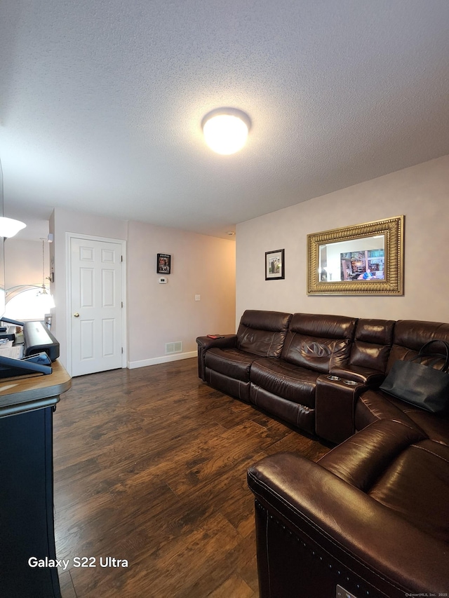 living room featuring dark hardwood / wood-style floors and a textured ceiling