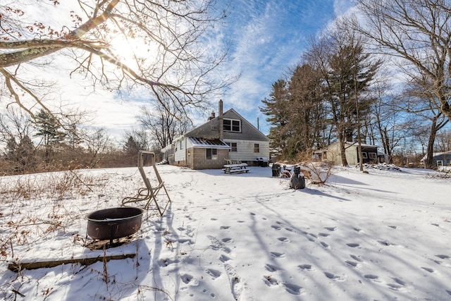 yard layered in snow featuring an outdoor fire pit