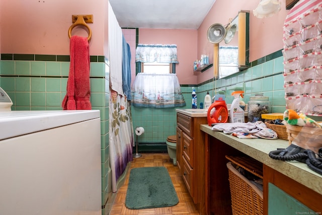 bathroom featuring tile walls, washer / dryer, parquet flooring, and toilet