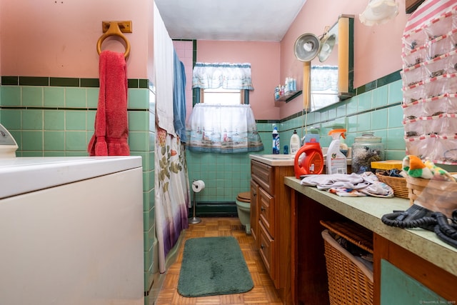108 Fall Mountain Rd, Bristol, CT 06010 - bathroom with tile walls, washer / dryer, wainscoting, vanity, and a shower with curtain