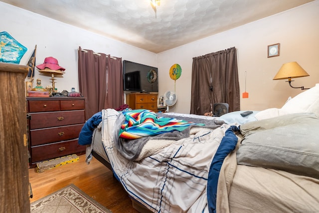 bedroom featuring hardwood / wood-style flooring and a textured ceiling