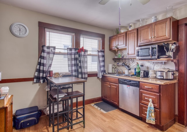 kitchen featuring sink, stainless steel appliances, ceiling fan, and light wood-type flooring