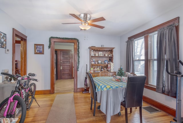 dining area with ceiling fan and light wood-type flooring