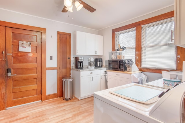 kitchen with washer / dryer, white cabinetry, ornamental molding, ceiling fan, and light hardwood / wood-style floors