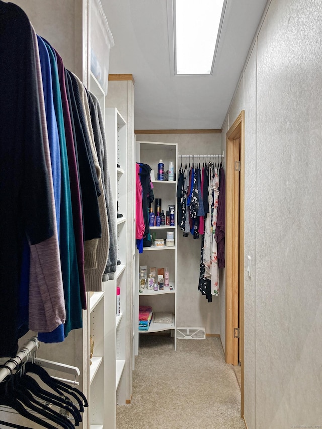 walk in closet featuring light colored carpet