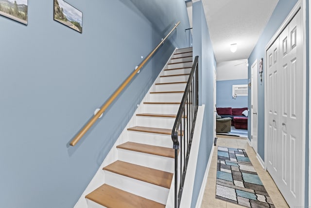 stairway featuring a textured ceiling