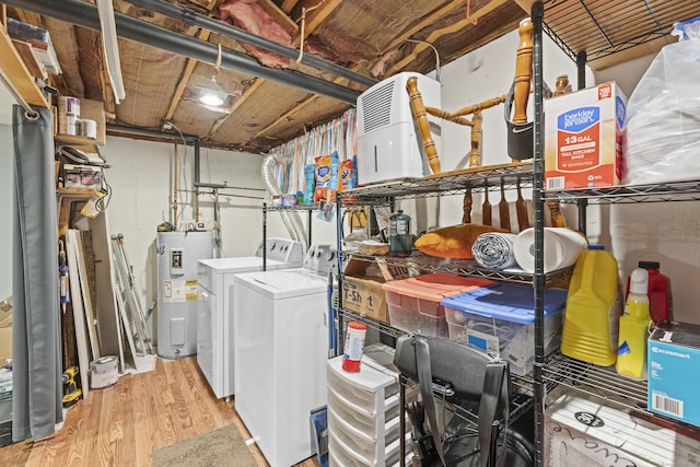 clothes washing area featuring light hardwood / wood-style flooring, washing machine and dryer, and water heater