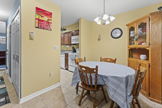 tiled dining room featuring an inviting chandelier