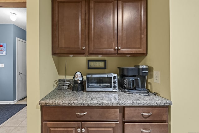 kitchen featuring light tile patterned floors and light stone countertops