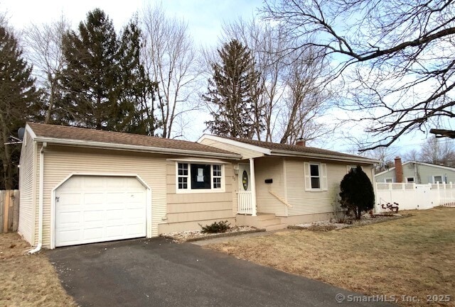 ranch-style house featuring a garage and a front yard