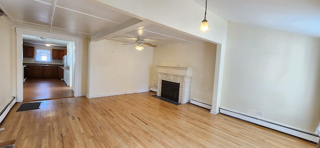 unfurnished living room with a baseboard heating unit, a fireplace, ceiling fan, and light wood-type flooring