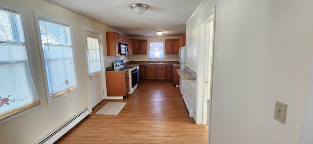 kitchen with light hardwood / wood-style flooring, white gas stove, and baseboard heating