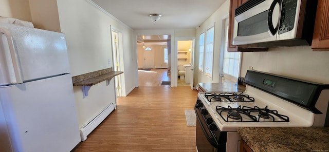 kitchen with white refrigerator, light hardwood / wood-style floors, range with gas cooktop, and baseboard heating