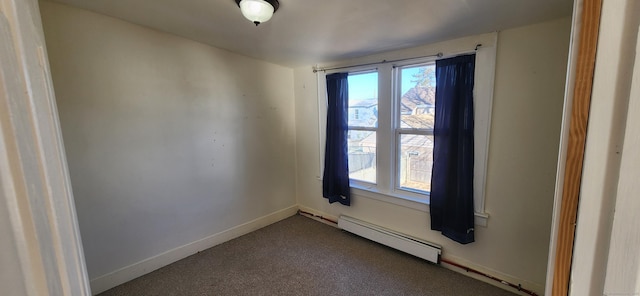 carpeted spare room featuring a baseboard heating unit and a wealth of natural light