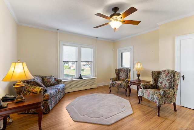 living area featuring ornamental molding, light hardwood / wood-style floors, and a healthy amount of sunlight