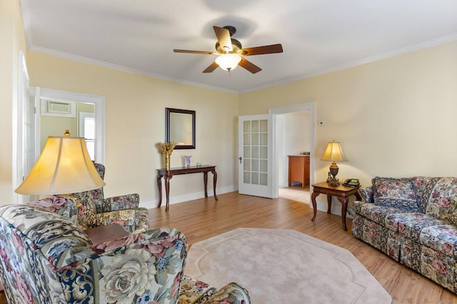 living room featuring ceiling fan, ornamental molding, light hardwood / wood-style floors, and a wall mounted air conditioner