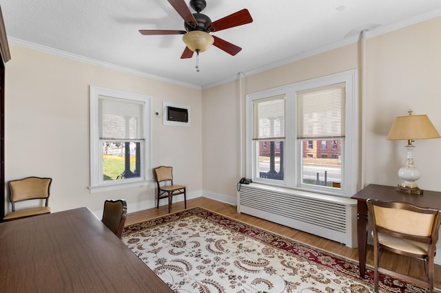 office with crown molding, radiator heating unit, ceiling fan, and light wood-type flooring