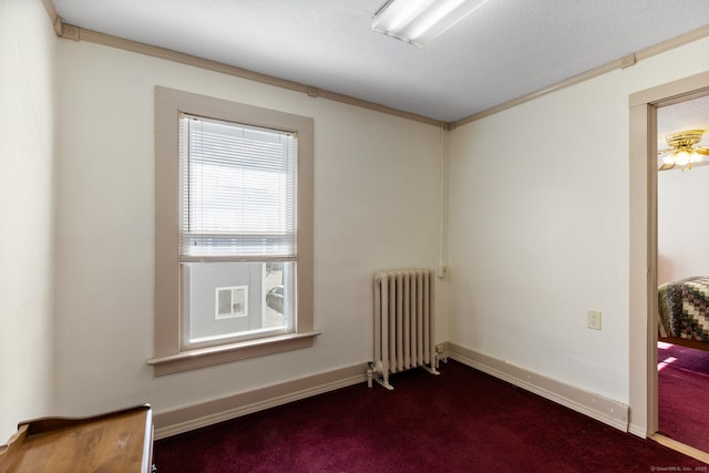 carpeted spare room featuring crown molding and radiator heating unit