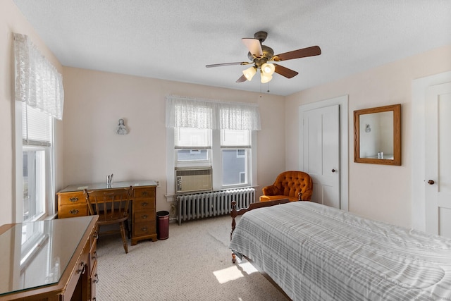 bedroom with radiator, ceiling fan, light carpet, a textured ceiling, and a closet