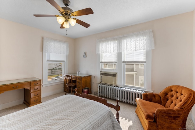 carpeted bedroom with ceiling fan, radiator heating unit, and multiple windows