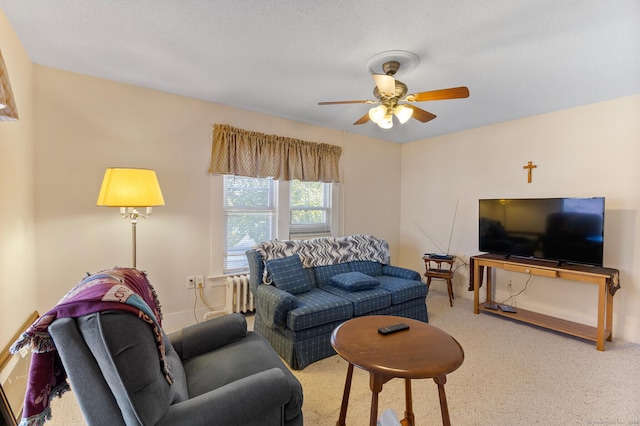 carpeted living room with ceiling fan and radiator