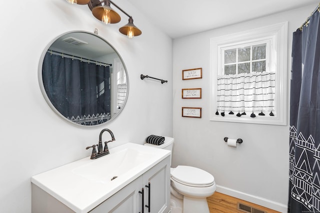 bathroom with hardwood / wood-style flooring, vanity, and toilet