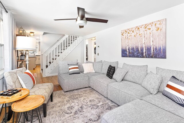 living room with sink, light hardwood / wood-style floors, and ceiling fan