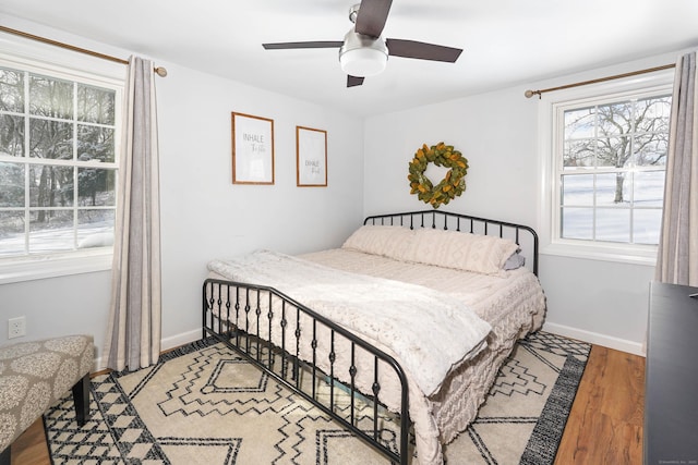 bedroom featuring light wood-type flooring, baseboards, and ceiling fan