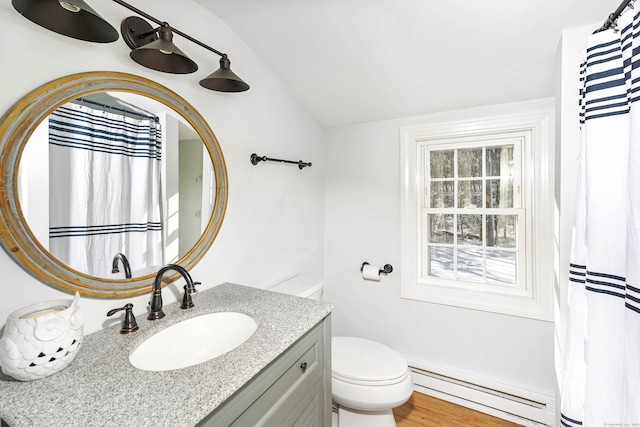 full bathroom with toilet, a baseboard heating unit, wood finished floors, vanity, and vaulted ceiling