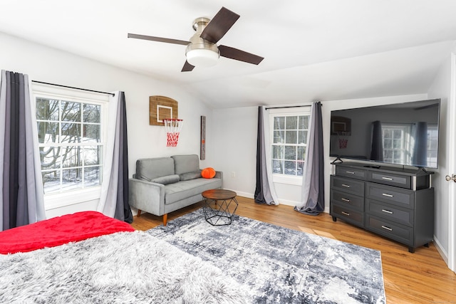 bedroom with ceiling fan, lofted ceiling, and light hardwood / wood-style flooring