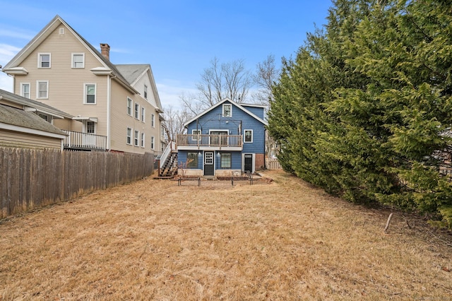 rear view of house featuring a deck and a lawn