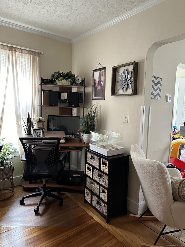 office with ornamental molding, wood-type flooring, and a textured ceiling