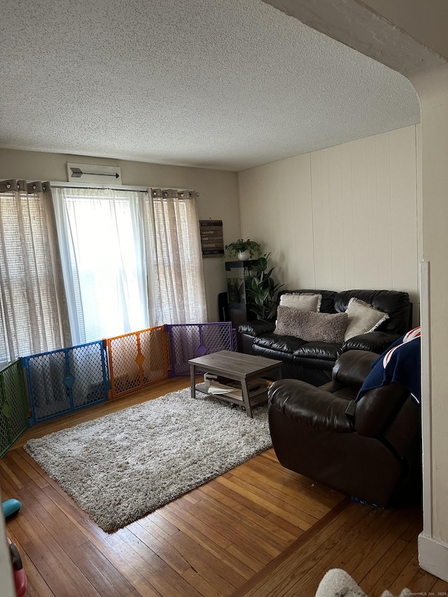 living room with wood-type flooring and a textured ceiling