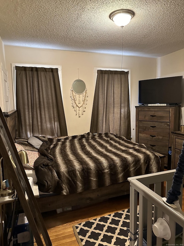 bedroom featuring hardwood / wood-style floors and a textured ceiling