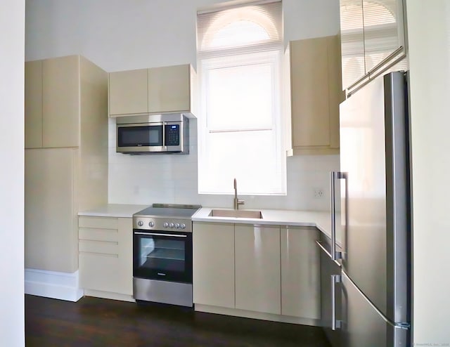 kitchen featuring stainless steel appliances, a healthy amount of sunlight, sink, and cream cabinetry