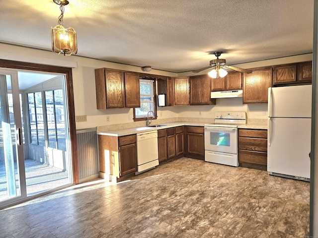 kitchen featuring sink, hanging light fixtures, white appliances, ceiling fan, and a textured ceiling