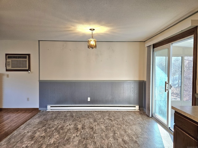 empty room featuring a baseboard radiator, a wall mounted AC, light hardwood / wood-style floors, and a textured ceiling