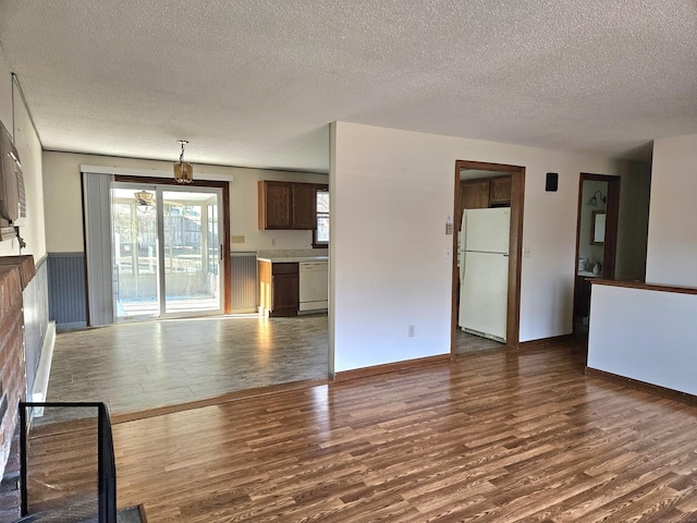 unfurnished living room with dark hardwood / wood-style floors and a textured ceiling