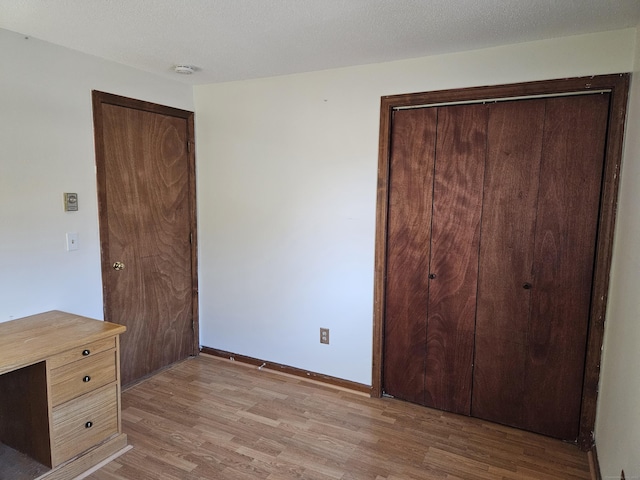 unfurnished bedroom with light hardwood / wood-style flooring and a textured ceiling