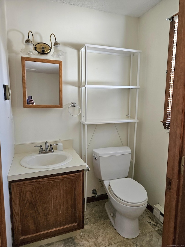 bathroom featuring vanity, toilet, and a baseboard heating unit