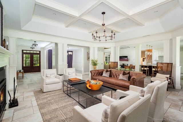 living room featuring ornate columns, ornamental molding, coffered ceiling, a notable chandelier, and french doors