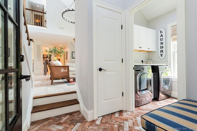 laundry room with washing machine and dryer and cabinets