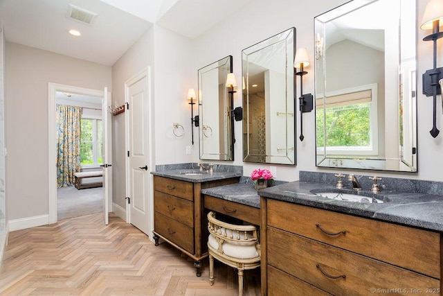 bathroom featuring parquet floors, a healthy amount of sunlight, and vanity