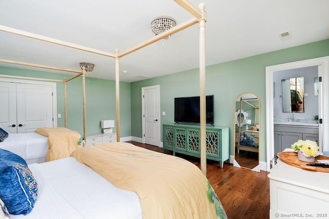 bedroom featuring dark wood-type flooring, connected bathroom, and sink