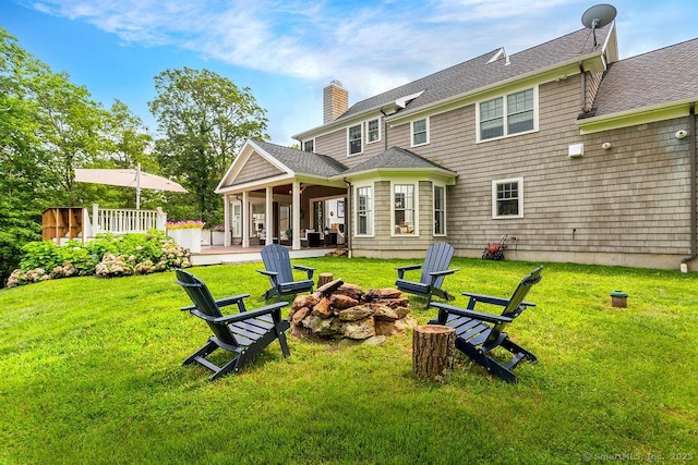 back of property featuring a patio, a lawn, and a fire pit