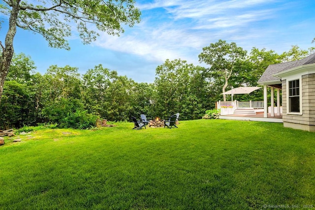 view of yard with a wooden deck and an outdoor fire pit