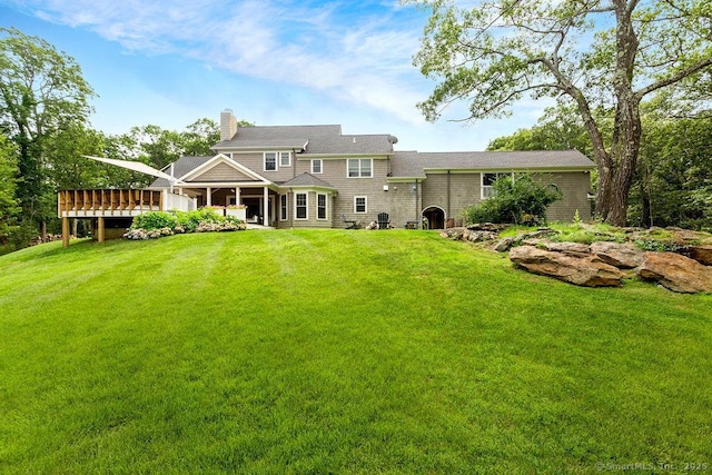 back of house featuring a wooden deck and a yard