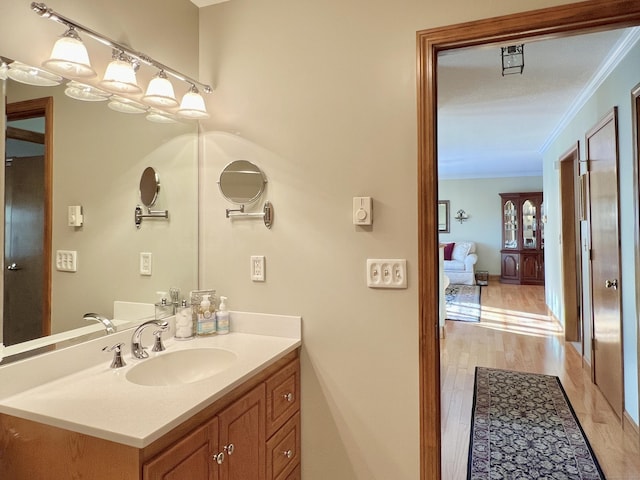 bathroom featuring crown molding, hardwood / wood-style floors, and vanity