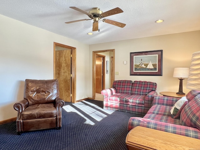 living room featuring ceiling fan, carpet flooring, and a textured ceiling