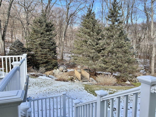 snowy yard featuring a wooden deck